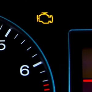 A car dashboard with a lit-up tire pressure warning light.