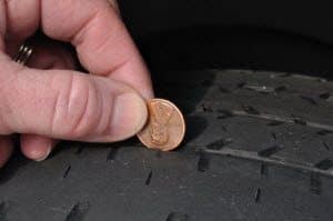 A car tire with visible signs of wear and tear, such as cracking and uneven tread.