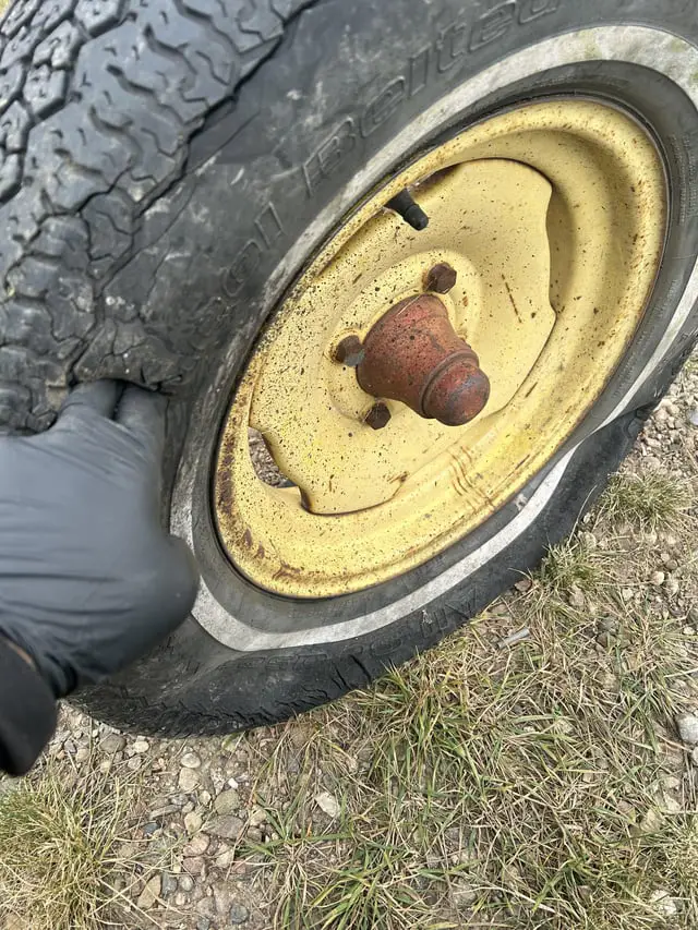 A close-up image of a severely worn-out tire with visible cracks and bald spots.